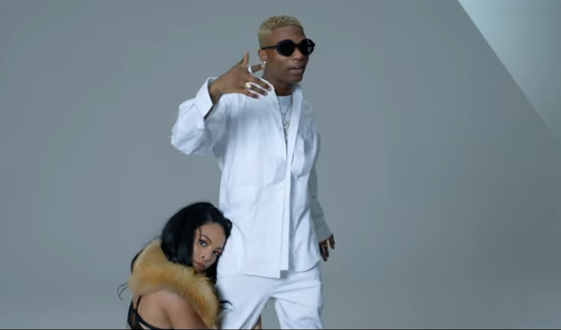 Photo of wizkid being held in the leg by a pretty lady