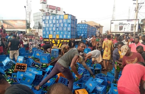 VIDEO: Residents shun social distancing to drink after truck conveying beer fell in Anambra