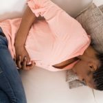Woman experiencing stomach pain due to fibroids