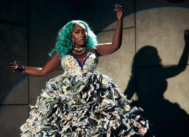 Jamaican singer Spice wearing a dollar note dress